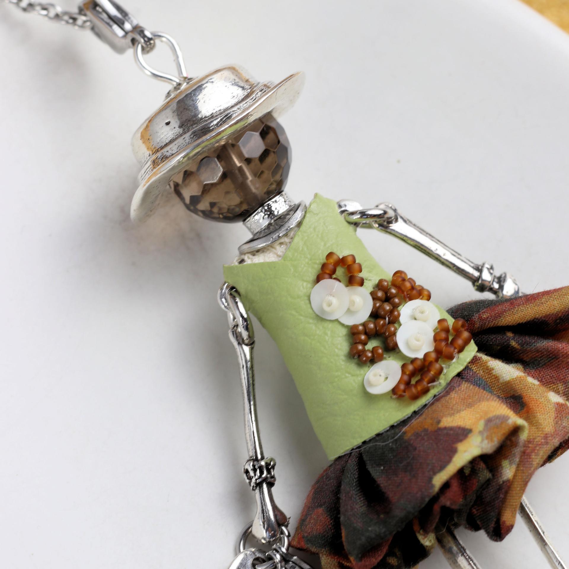 Haut en simili cuir vert clair brodé main de perles marron et de sequins crème, détail d'un collier vert femme.