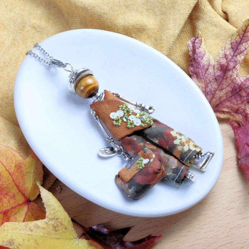 Collier pierre œil de tigre en forme de poupée articulée, tenue brodée et pantalon fleuri aux tons d'automne